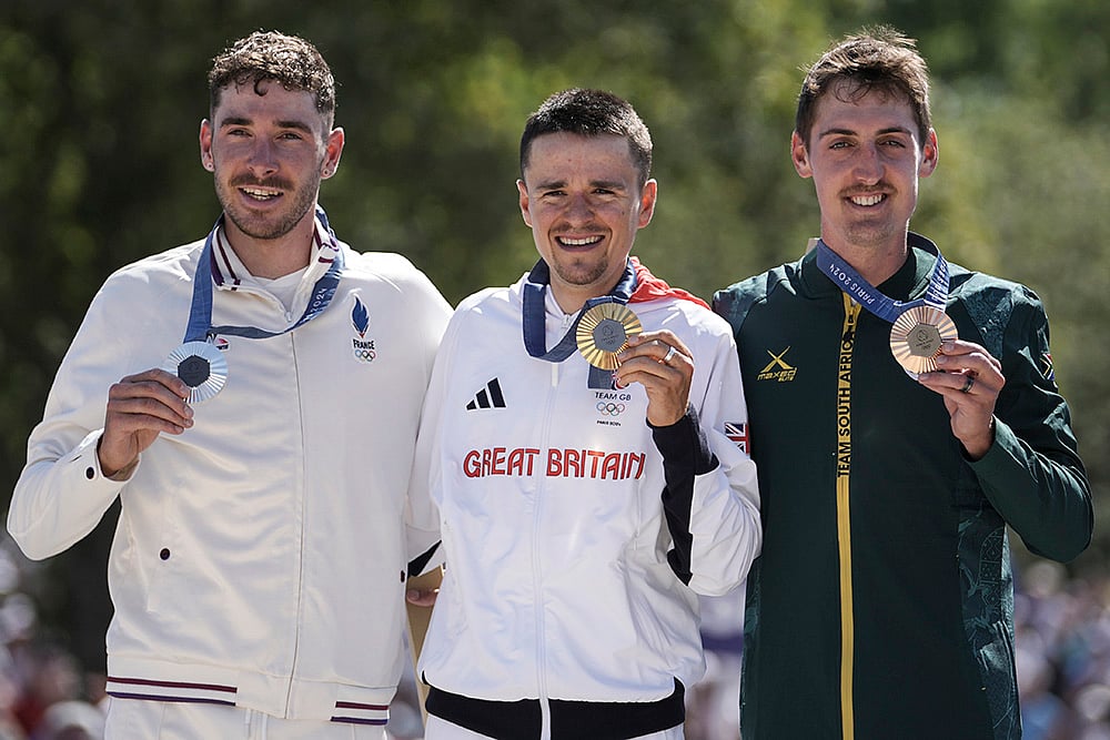 | Photo: AP/Thibault Camus : Men's mountain bike race: Gold medalist Thomas Pidcock, of Britain, center, silver medallist Victor Koretzky, of France, left, and bronze medallist Alan Hatherly, of South Africa